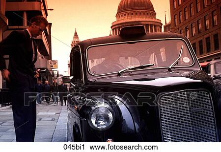 Stock Image - Businessman Paying Fare Outside Taxi London. Fotosearch