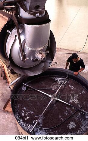 Stock Image - Worker Inspecting Coffee Roasting Production Plant. Fotosearch