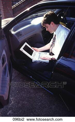 Stock Image - Man Sitting in Car with Laptop Computer. Fotosearch