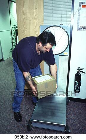 Stock Image - Workman Bending Down to Weigh a Package. Fotosearch