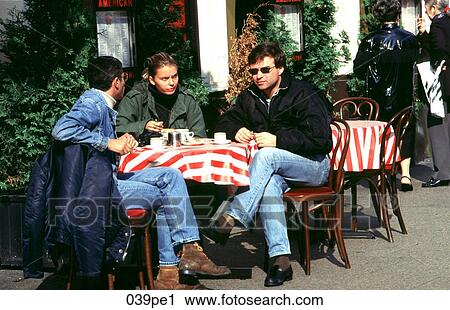 Three People Sitting at a Table in an Outside Cafe View Large Photo Image Stock Image - Three People Sitting at a Table in an Outside Cafe. Fotosearch