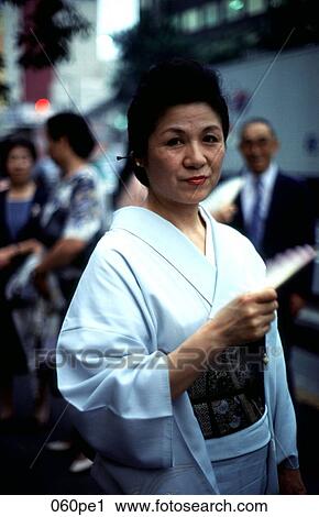 Stock Image - Woman in a Kimono Holding a Fan Japan. Fotosearch