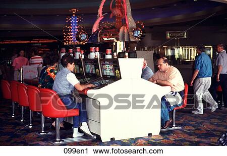 Stock Image - Gamblers at Machines in Las Vegas Casino USA. Fotosearch