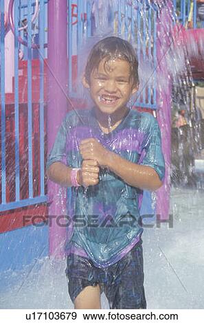 A boy under a water fountain at amusement park View Large Photo Image Stock Photo - A boy under a water fountain at amusement park. Fotosearch
