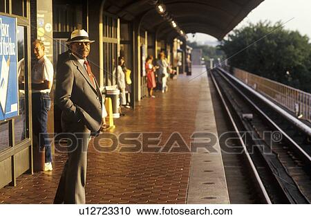 A business man stands waiting for a Metro rail commuter train at sunrise View Large Photo Image Stock Image - A business man stands waiting for a Metro rail commuter train at sunrise. Fotosearch