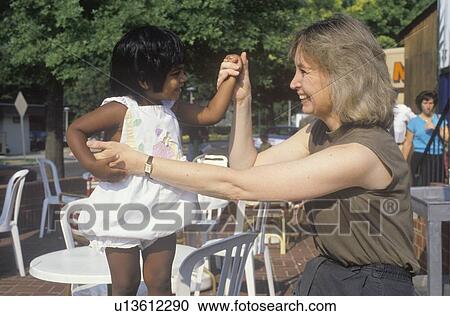 Stock Image - A Caucasian woman playing with an Indian child. Fotosearch