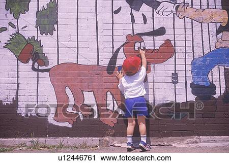 A little boy pointing to a graffiti character on a wall View Large Photo Image Stock Image - A little boy pointing to a graffiti character on a wall. Fotosearch