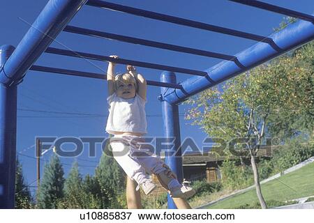 Stock Photo - A little girl playing on the jungle gym. Fotosearch