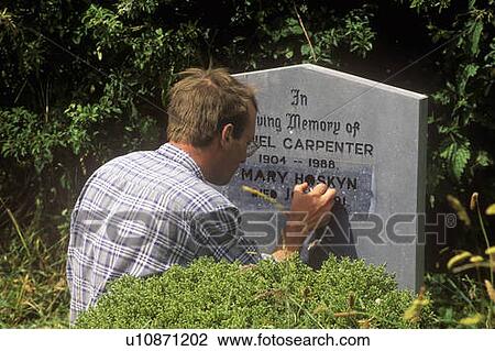 Stock Image - A man carving a gravestone. Fotosearch