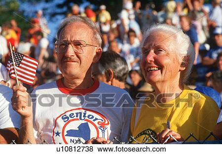 Stock Photo - A patriotic senior couple watching the Senior Olympics. Fotosearch