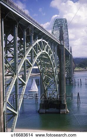 Picture - A sailboat under an arched bridge over Yaquina Bay at Newport, Oregon. Fotosearch