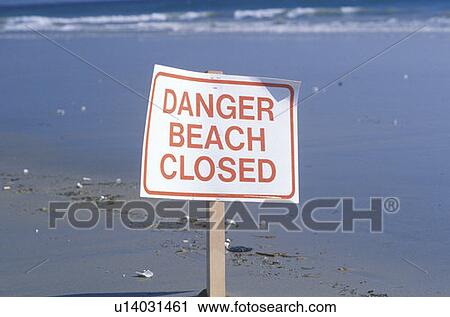 Stock Image - A sign reads danger beach closed. Fotosearch