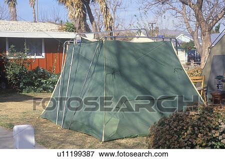 Stock Photo - A tent set up in a yard housing people displaced by earthquake. Fotosearch