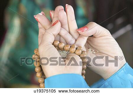 A woman's hands hold prayer beads and rice View Large Photo Image Stock Photography - A woman's hands hold prayer beads and rice. Fotosearch