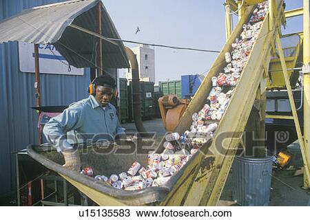 A worker overseeing aluminum cans moving along a conveyor at a recycling center View Large Photo Image Stock Image - A worker overseeing aluminum cans moving along a conveyor at a recycling center. Fotosearch