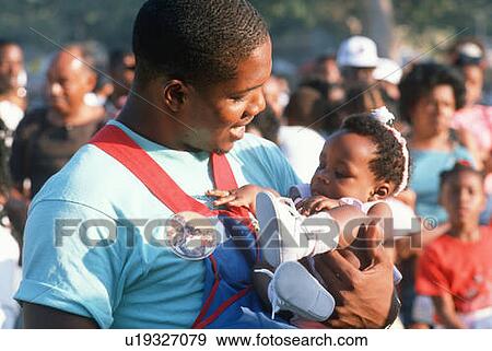 Stock Photo - African American father holding his baby. Fotosearch