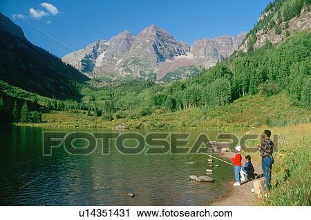 Stock Image - African American man and two children fishing on Maroon Lake, Colorado. Fotosearch