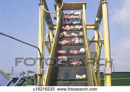 Stock Image - Aluminum cans moving along a conveyor at a recycling center. Fotosearch