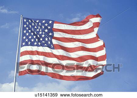 Stock Photo - American Flag Flying Against Blue Sky, United States. Fotosearch