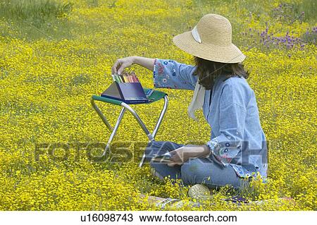 Stock Image - An artist sketching spring flower fields. Fotosearch