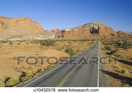 An empty road runs through red rock in the desert southwest USA View Large Photo Image Stock Photo - An empty road runs through red rock in the desert southwest USA. Fotosearch