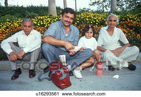 Stock Image - An Indian family sitting on the curb. Fotosearch