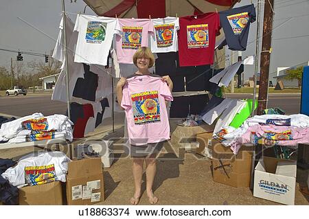 Blond woman holds up T-shirt View Large Photo Image Picture - Blond woman holds up T-shirt. Fotosearch