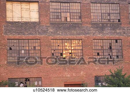 Stock Photo - Broken windows of an abandoned brick factory building. Fotosearch