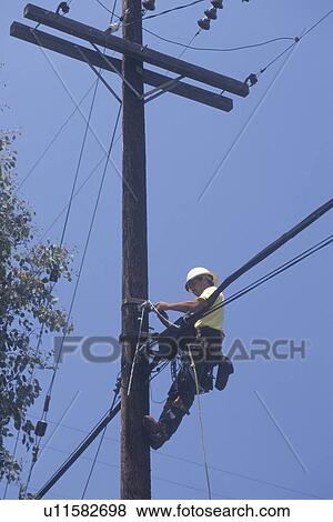 Stock Photo - Cable television repairman on a telephone pole. Fotosearch
