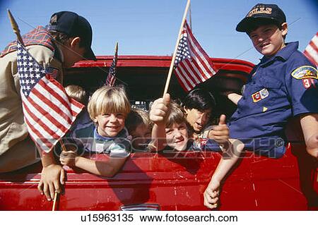 Cub Scouts waving American flags from back of car View Large Photo Image Stock Photography - Cub Scouts waving American flags from back of car. Fotosearch