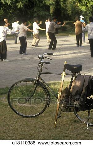 Stock Photograph - Early morning Tai Chi (taijiquan) exercises in the park. Fotosearch