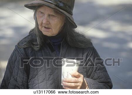Stock Photograph - Elderly homeless woman drinking cup of coffee. Fotosearch