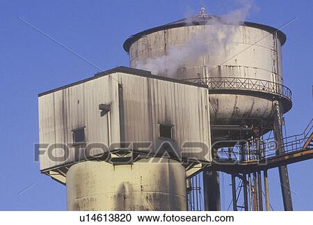 Factory smokestacks with smoke and a blue sky View Large Photo Image Stock Image - Factory smokestacks with smoke and a blue sky. Fotosearch