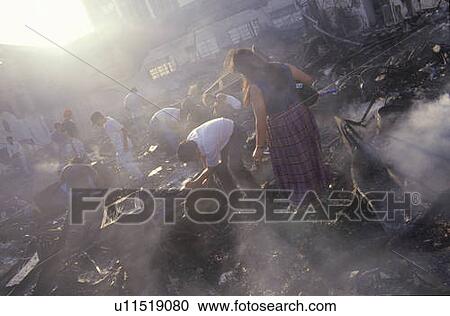 Stock Image - Family salvaging possessions after riots. Fotosearch