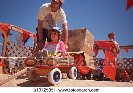 Stock Image - Father and daughter at Soap Box Derby, Venice California. Fotosearch