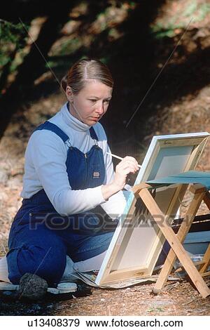 Stock Photo - Female artist painting on canvas. Fotosearch