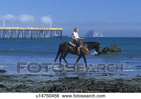 Stock Photograph - Girls riding horseback on beach. Fotosearch