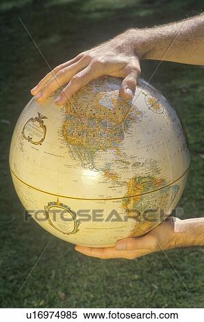 Hands holding a globe over a patch of grass View Large Photo Image Stock Photography - Hands holding a globe over a patch of grass . Fotosearch