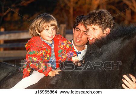 Picture - Little girl on horseback with her parents. Fotosearch