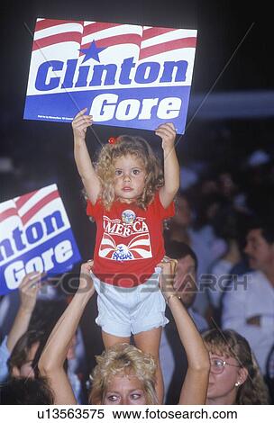 Stock Photography - Little girl with Clinton/Gore sign stands out in the crowd. Fotosearch