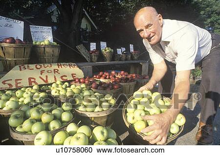 Stock Image - Man holding green apples. Fotosearch