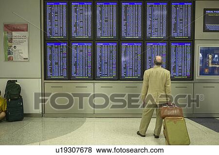 Stock Photo - Man with luggage in airport. Fotosearch