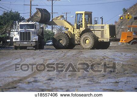 Stock Photograph - Men and equipment cleaning up after the mudslides. Fotosearch