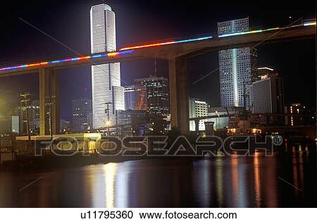 Stock Image - Miami skyline by night, Centrust Building and Metro Rail, Miami, Florida. Fotosearch