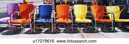 Stock Photograph - Multi-colored metal lawn chairs. Fotosearch