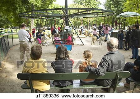 Parents and children at carousel ride in park, Paris, France View Large Photo Image Stock Photograph - Parents and children at carousel ride in park, Paris, France. Fotosearch