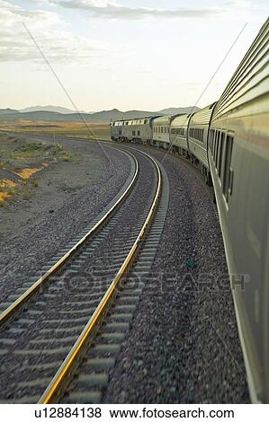 Stock Photo - Passenger train traveling into the Arizona sunset. Fotosearch