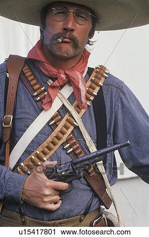 Stock Image - Portrait of Old West gunslinger participant with pistols. Fotosearch