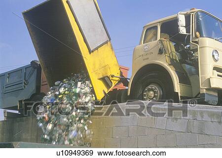 Stock Photo - Recyclable materials falling from a recycling truck into a bin at a recycling center . Fotosearch
