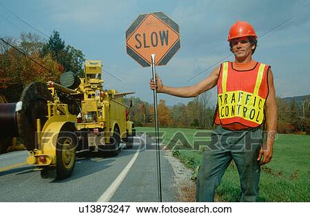 Stock Photo - Road crewman holding traffic control sign. Fotosearch